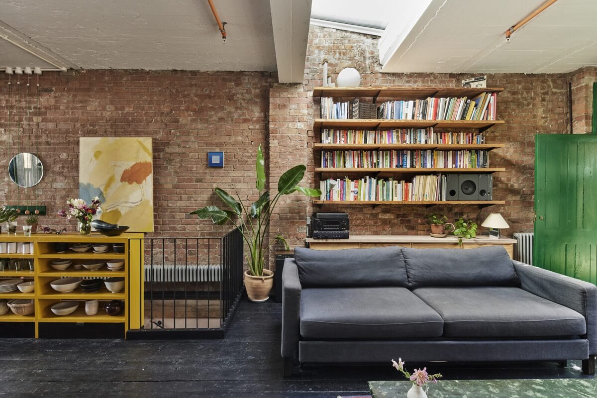 A Unique Home in a Former Furniture Workshop 4 living-room-brick-walls-black-wooden-floor-floating-bookshelfs-nordroom