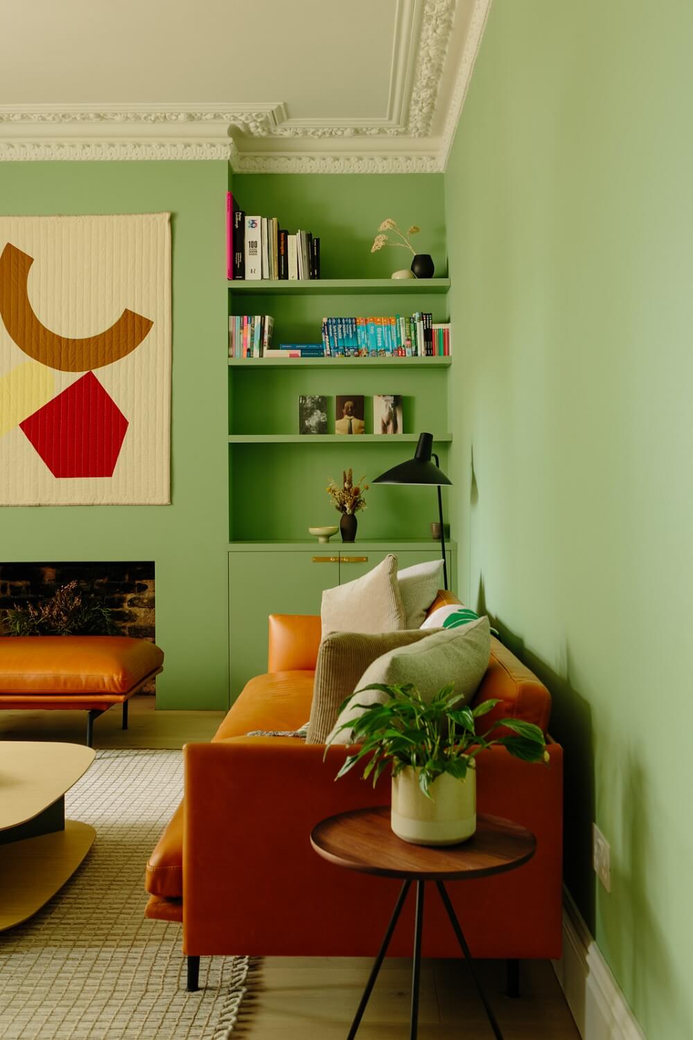 A London Home with a Cheerful Green Sitting Room 2 living-room-tan-leather-sofa-green-walls-shelves-nordroom