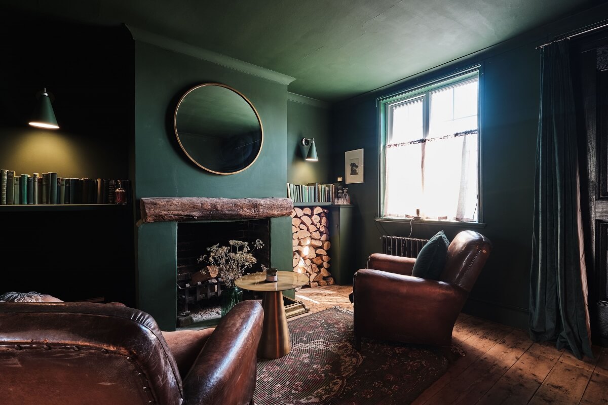 Bold Colors in a Charming English Cottage 1 moody-dark-green-sitting-room-leather-club-chairs-nordroom