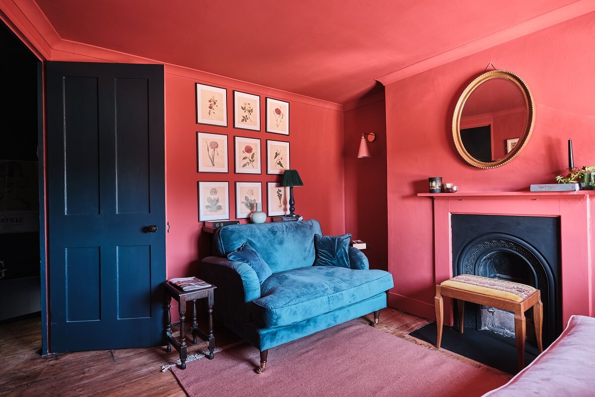Bold Colors in a Charming English Cottage 11 pink-walls-ceilng-blue-sofa-black-fireplace-english-cottage-nordroom