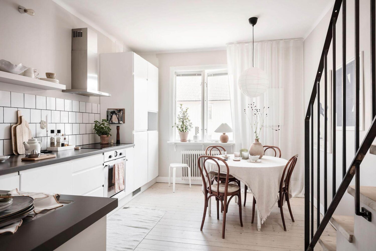 A Living Room with Pink Accents in a Light Attic Apartment 13 scandinavian-kitchen-white-cabinets-round-table-nordroom