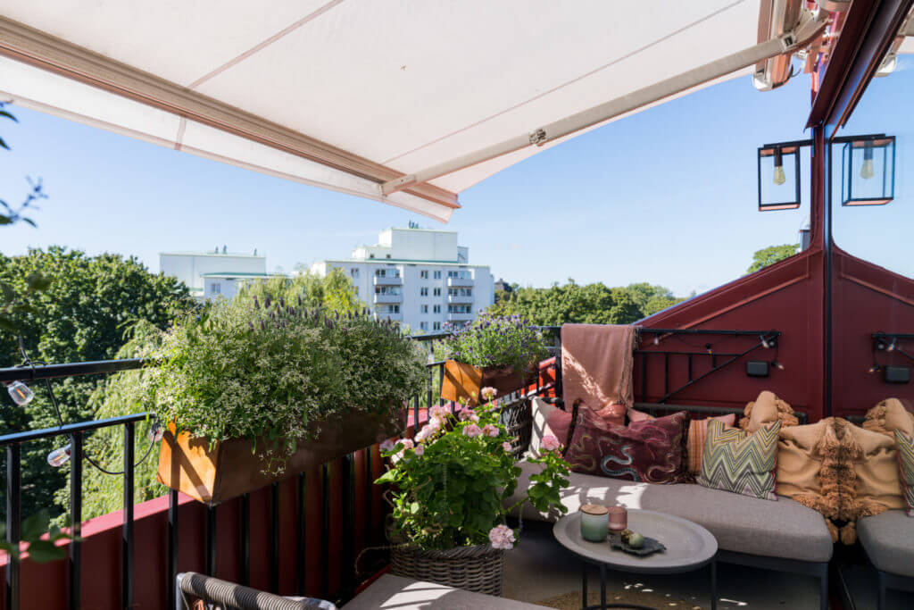 A Small Attic Apartment with Plenty of Storage 16 cozy-balcony-plants-seating-nordroom