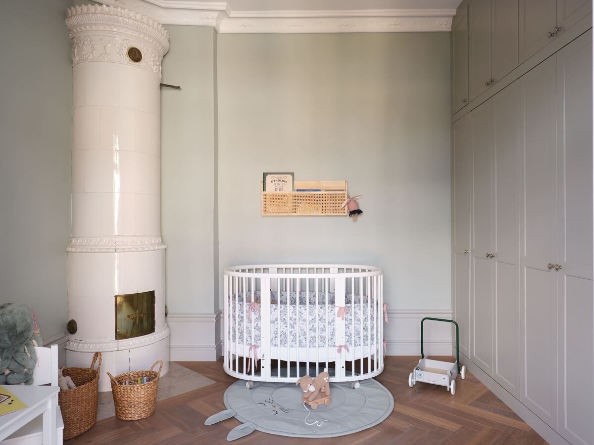 A Stylish Nordic Apartment with Attic Bedroom 15 light-gray-baby-room-nursery-built-in-cabinets-fireplace-nordroom