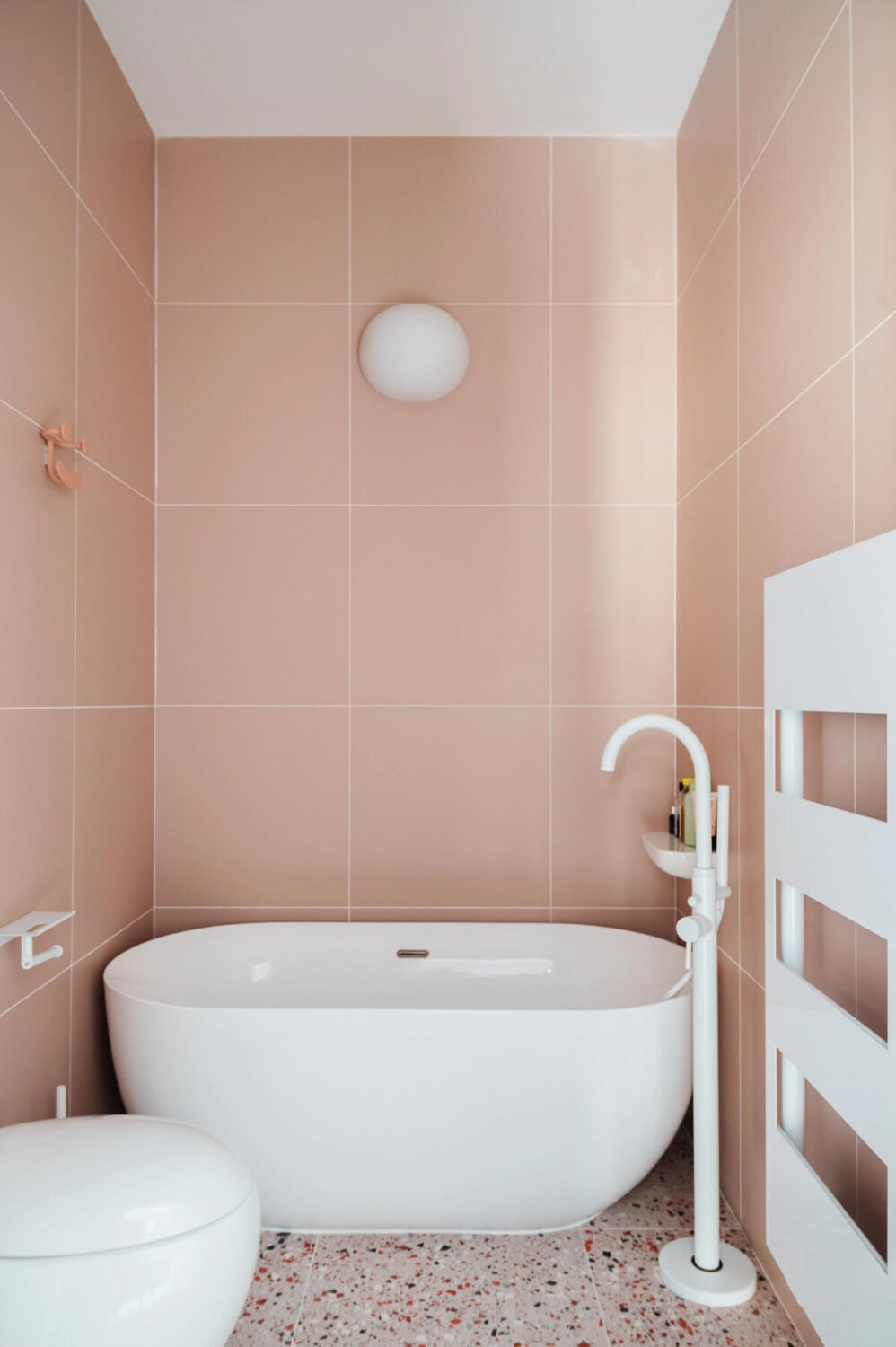89 Pink Bathroom Ideas: From Hot Pink Walls to Blush Tiles 54 narrow-bathroom-pink-tiles-white-bath-nordroom