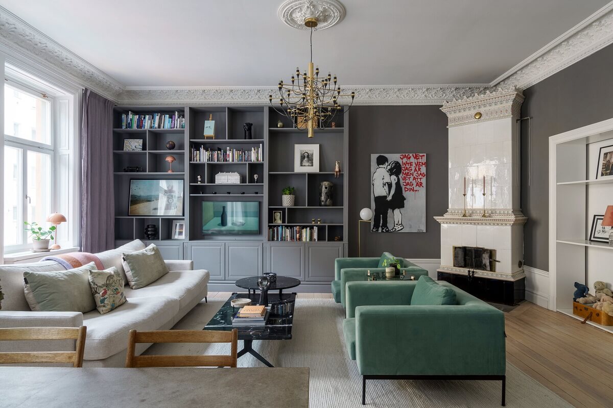 A Classic Nordic Apartment Decorated with Modern Furnishings and Color 3 open-plan-living-room-green-armchairs-fireplace-bookcase-nordroom