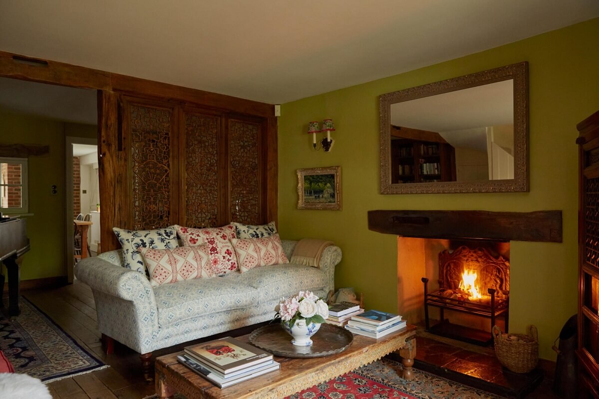 cottage-sitting-room-green-walls-fireplace-carved-wooden-wall-nordroom
