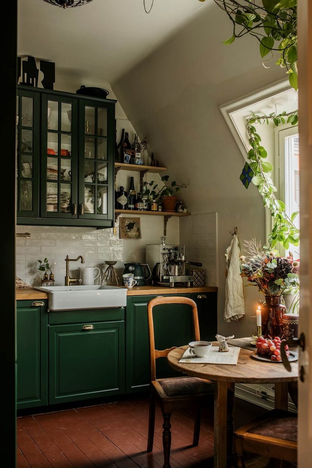 A Colored Sixth Wall May Be The Biggest Paint Trend in 2026 3 cozy-green-kitchen-cabinets-slanted-ceiling-small-dining-table-terracotta-floor-tiles-nordroom