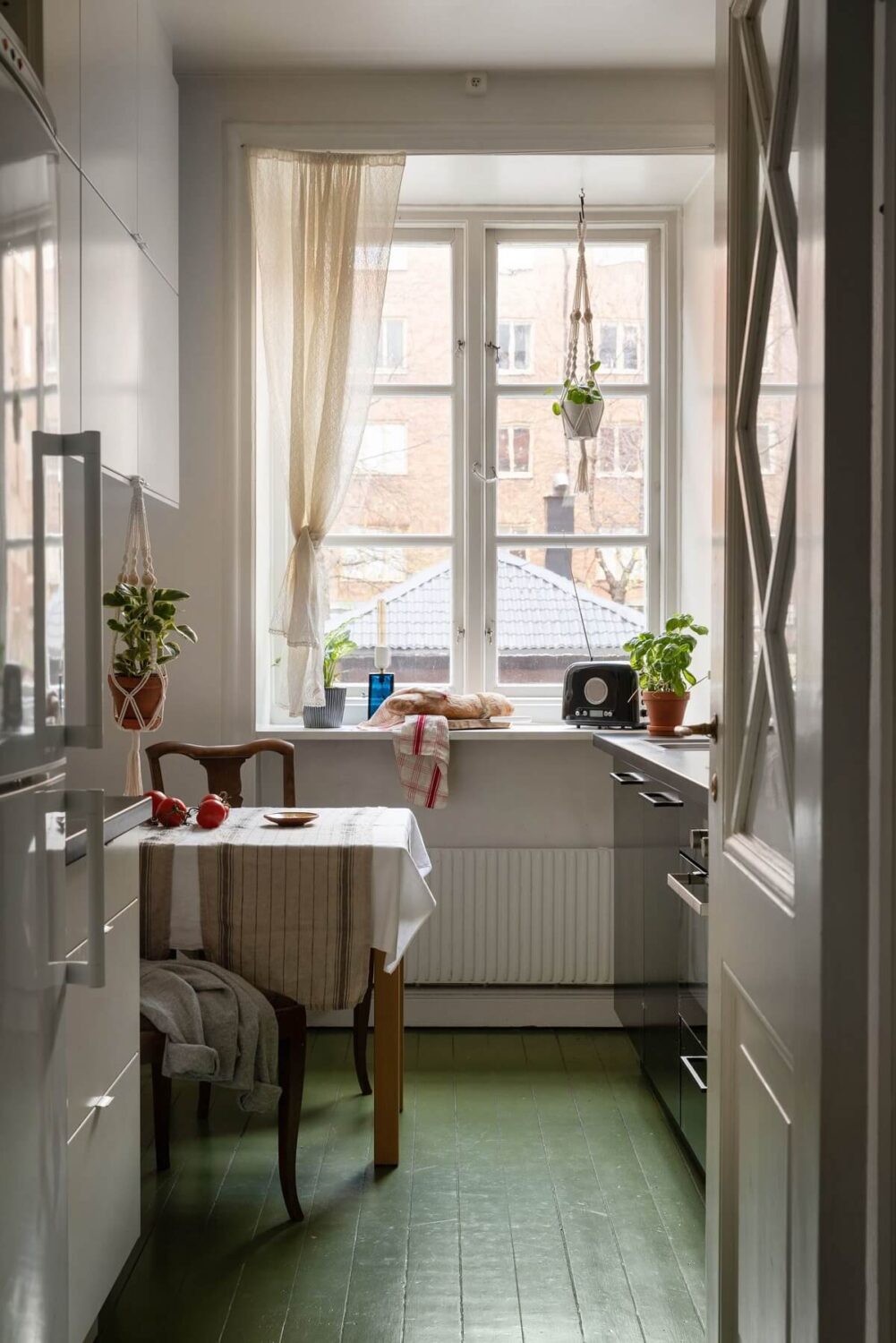 A Cozy Apartment Painted in Warm Natural Colors 15 green-wooden-floor-small-kitchen-black-cabinets-nordroom