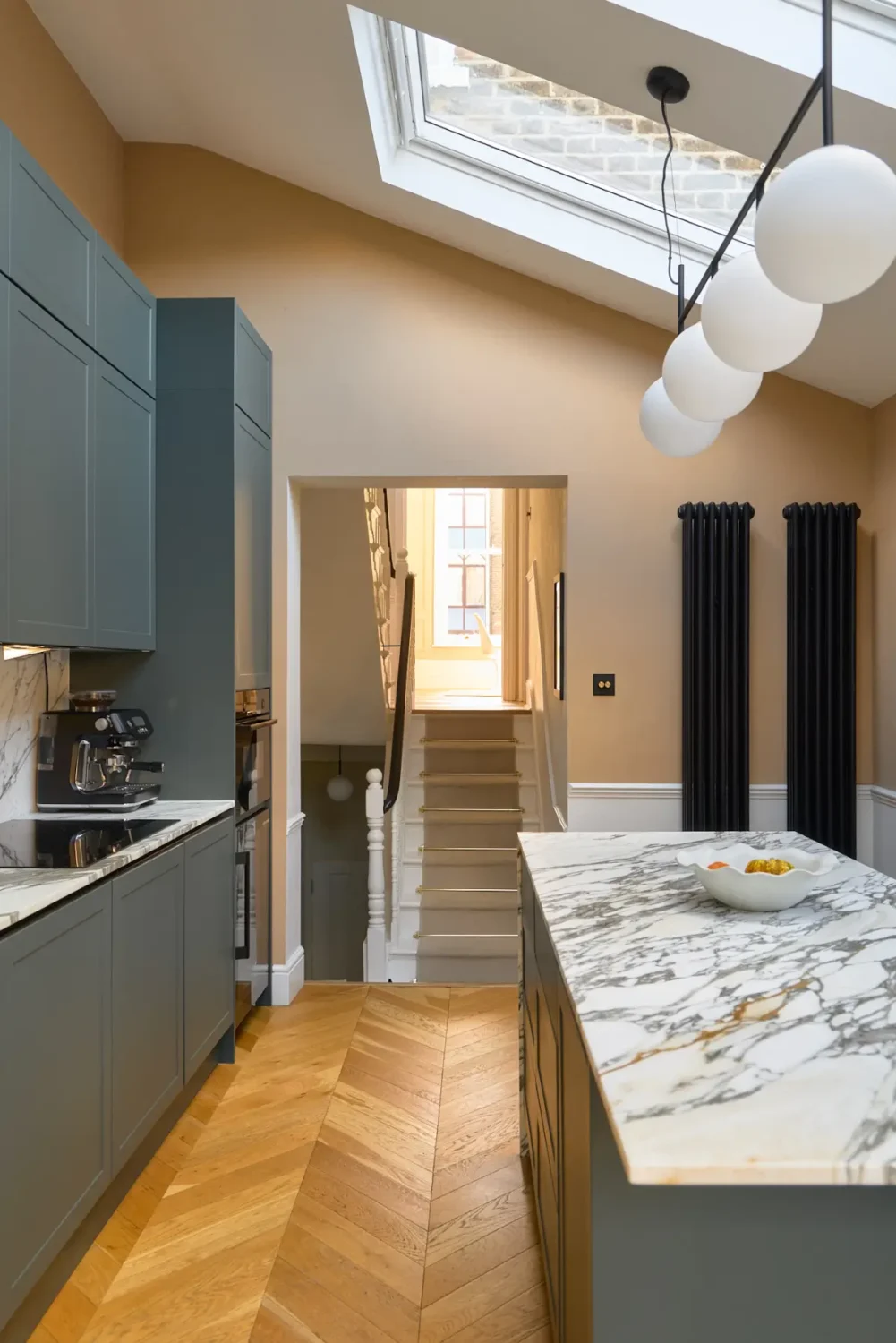 Herringbone vs. Chevron Flooring Patterns: Differences & Inspiration 7 kitchen-green-cabinets-chevron-parquet-floor-skylight-nordroom