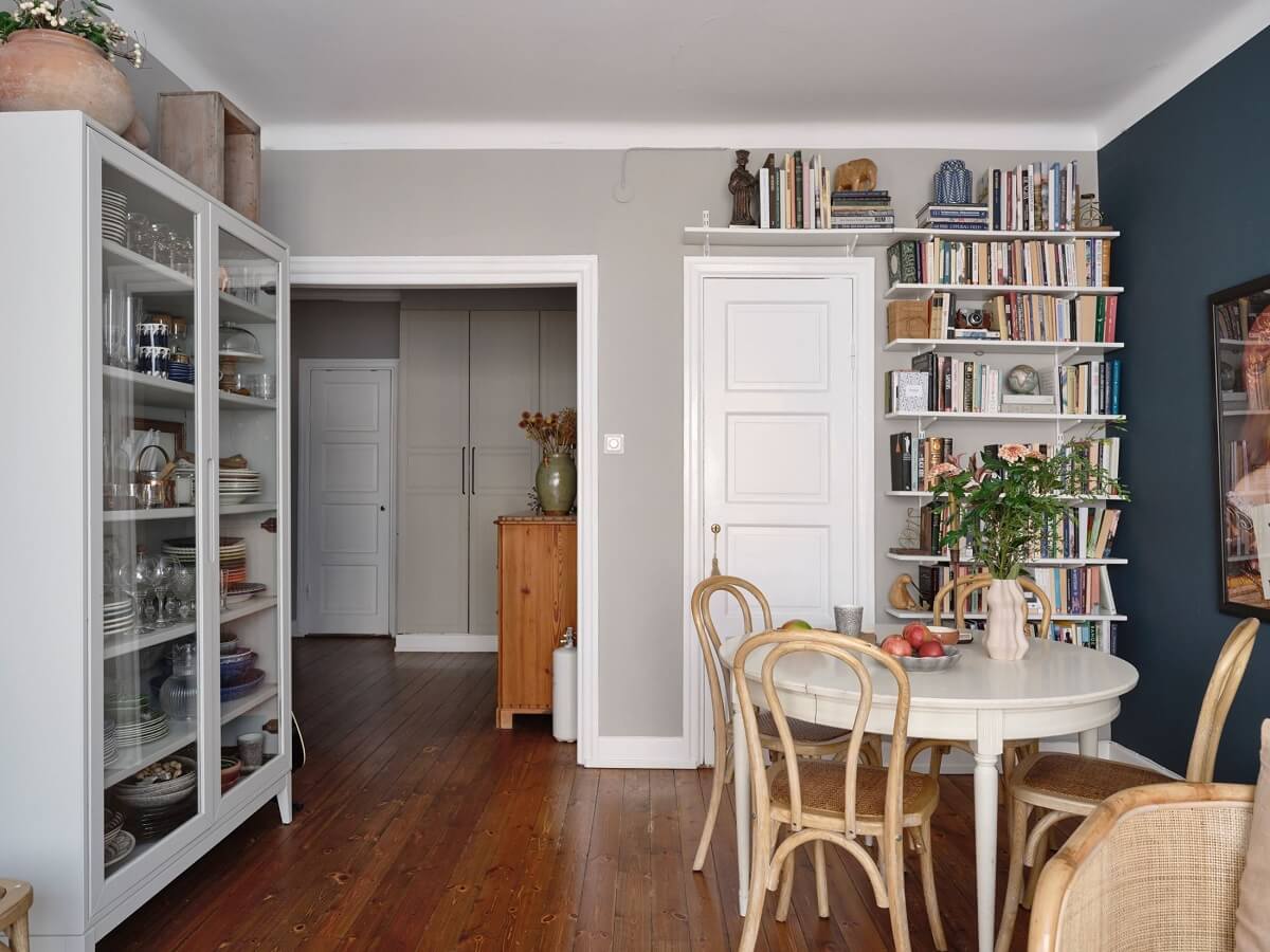 A Small Nordic Home with Dark Blue Accent Walls 8 living-room-wooden-floor-round-table-shelves-nordroom