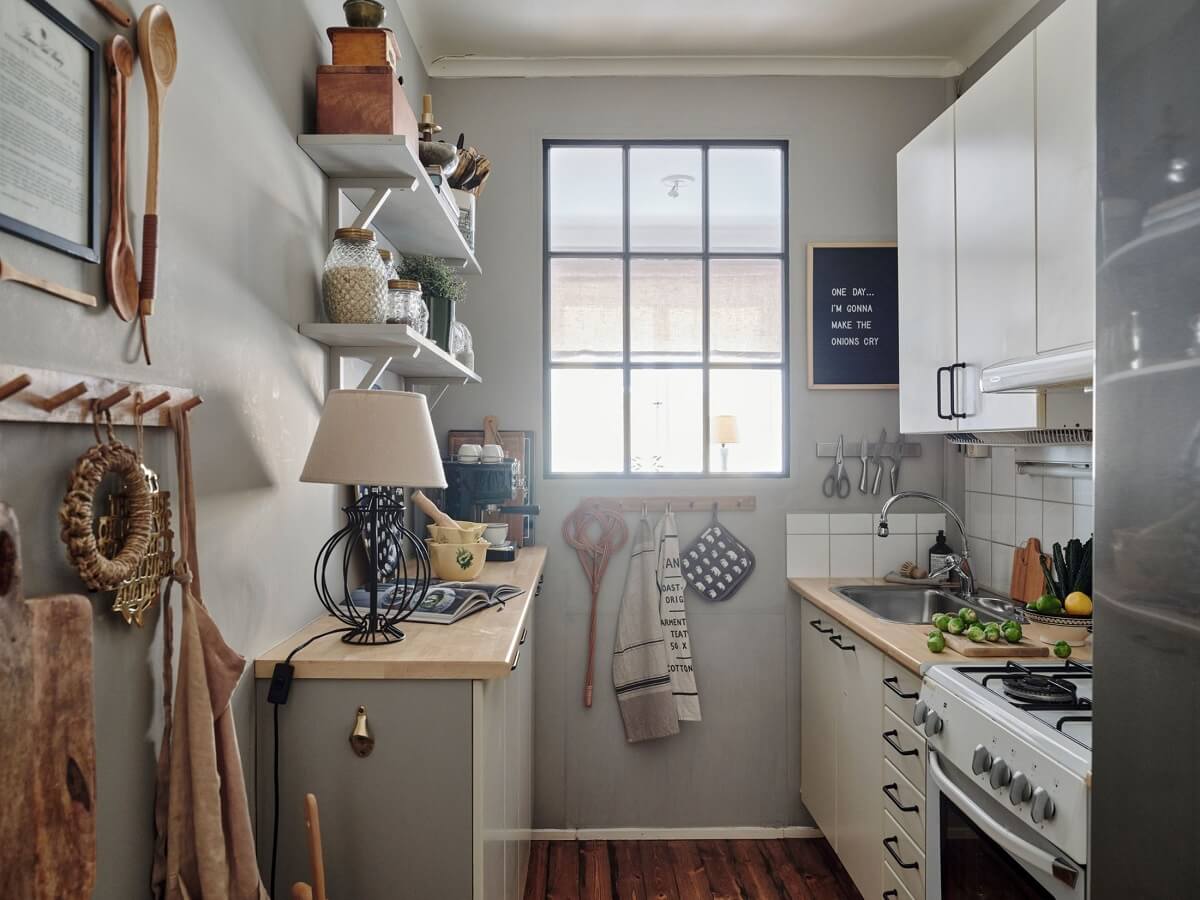 A Small Nordic Home with Dark Blue Accent Walls 11 small-galley-kitchen-light-gray-walls-shelves-window-nordroom