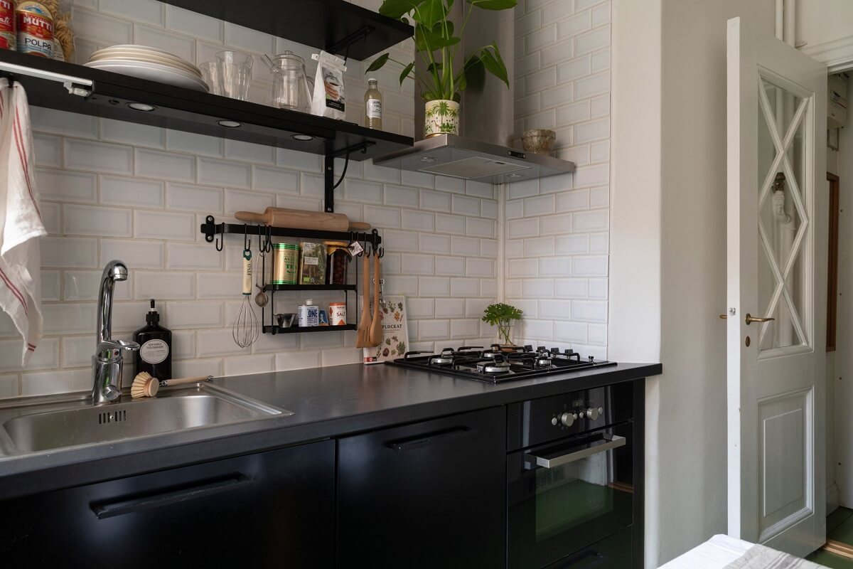 A Cozy Apartment Painted in Warm Natural Colors 17 small-kitchen-black-cabinets-open-shelves-white-tiles-nordroom