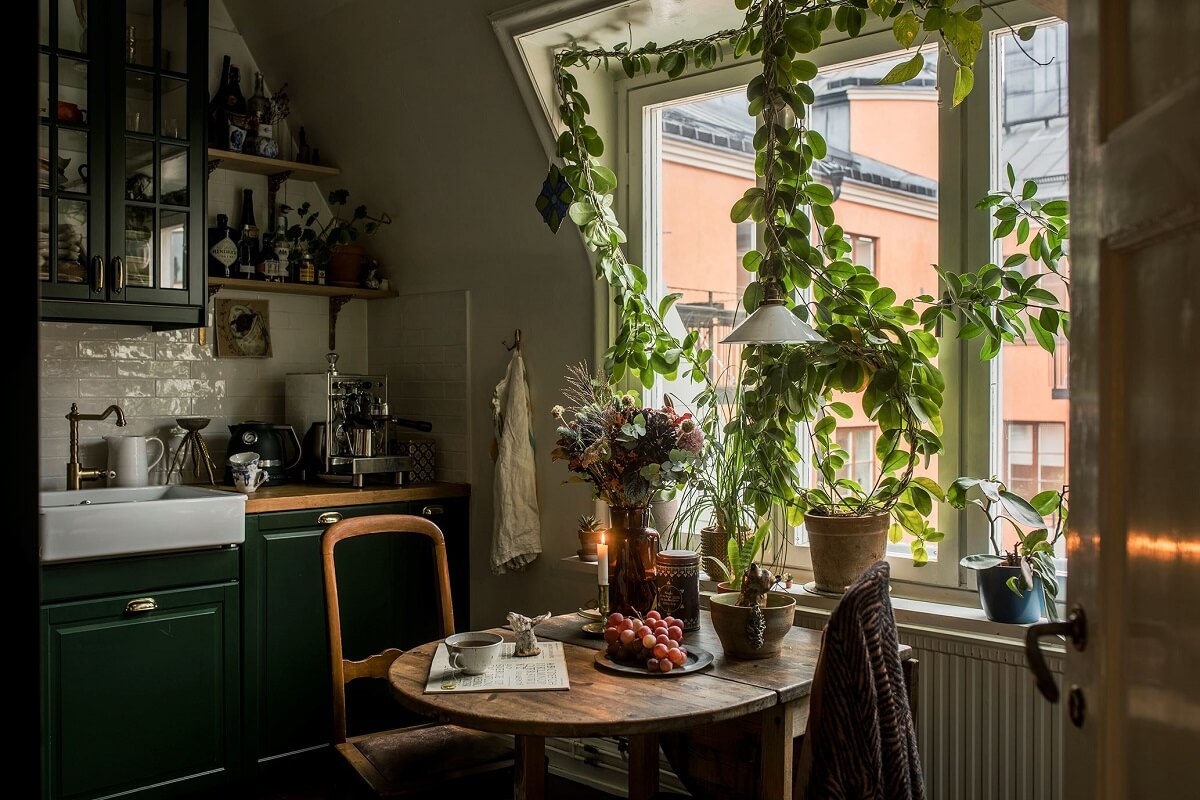 A Cozy Green Kitchen in a Vintage Attic Apartment 2 small-kitchen-slanted-wall-plants-green-cupboards-nordroom