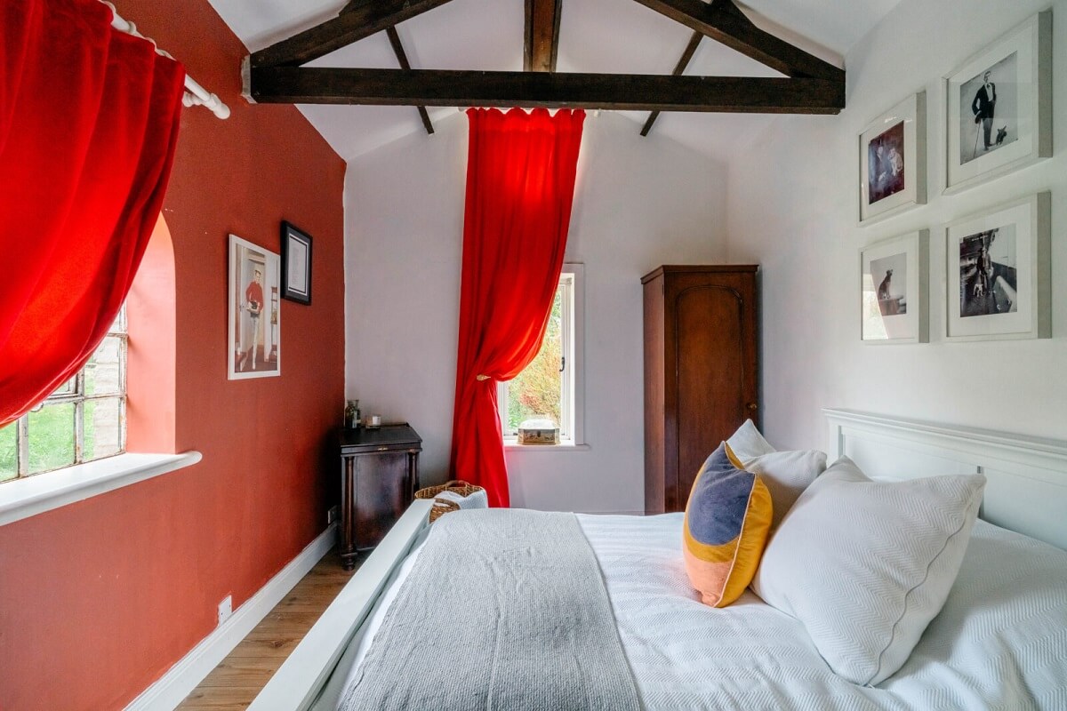 An English Barn Conversion Decorated in Green and Blue 13 bedroom-exposed-wooden-beams-red-wall-nordroom