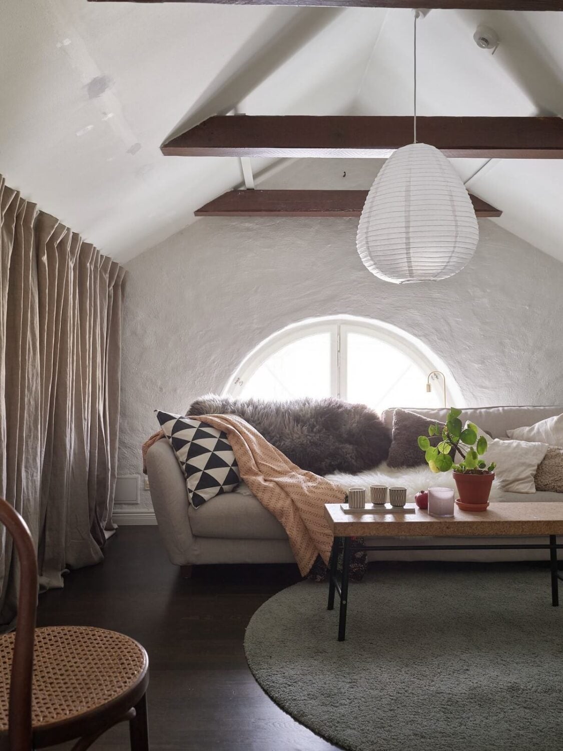 A Swedish Maisonette with a Charming Kitchen 13 cozy-sitting-room-slanted-ceilings-exposed-wooden-beams-gray-sofa-nordroom
