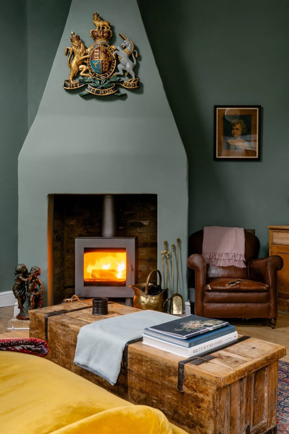 An English Barn Conversion Decorated in Green and Blue 3 fireplace-sitting-room-green-walls-trunk-coffee-table-nordroom