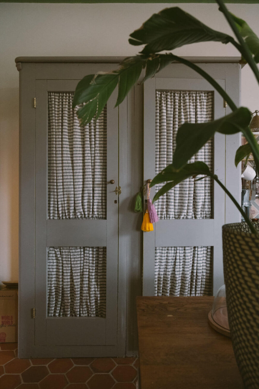 A Colorful Vintage Eclectic Home in England 14 gray-kitchen-pantry-curtains-terracotta-floor-tiles-nordroom