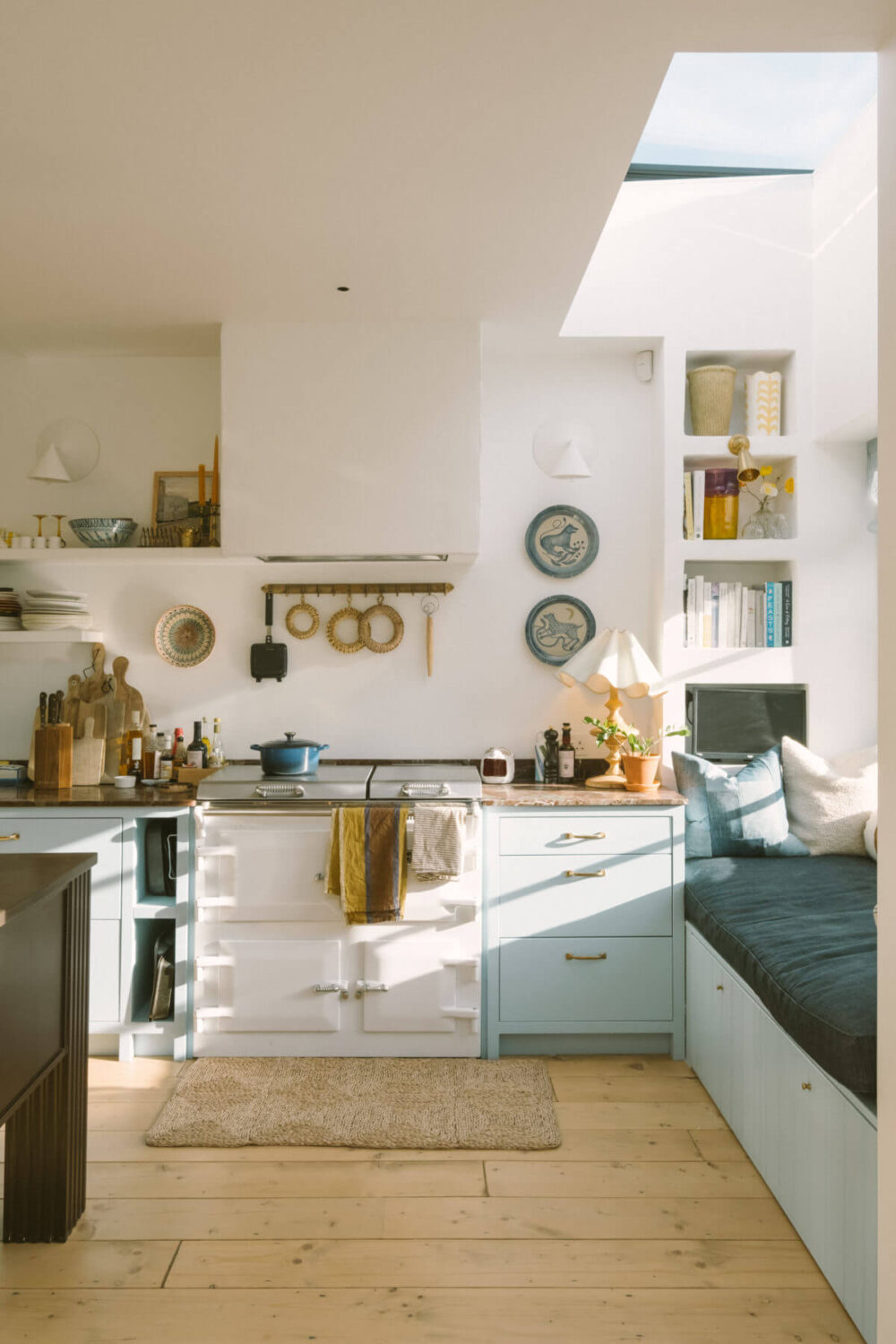 Valspar Color of the Year 2024: Renew Blue 10 kitchen-window-seat-skylight-light-blue-cabinets-aga-stove-wooden-floor-nordroom