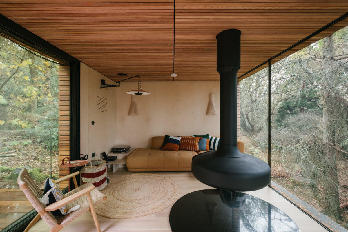 A Modern Woodland Lodge with A Scandi Interior 5 living-room-scandinavian-style-hanging-fireplace-modern-lodge-floor-to-ceiling-windows-nordroom