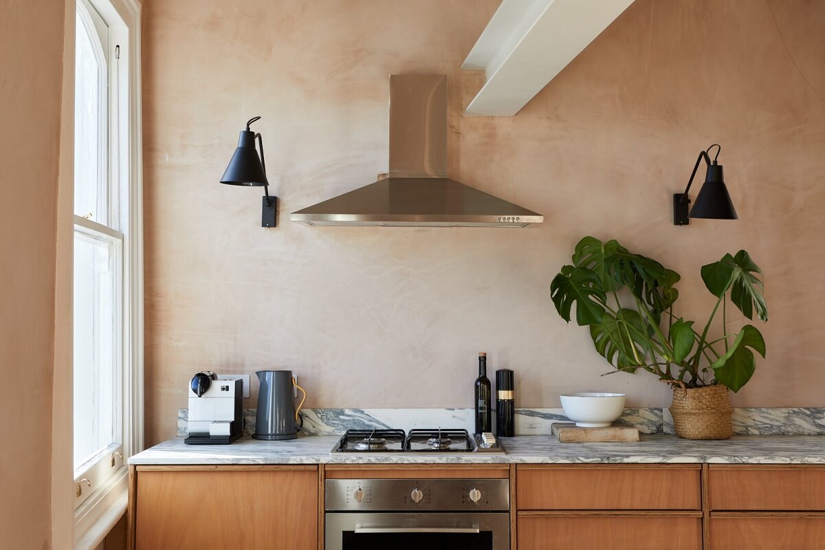 A London Home with Plaster Pink Walls and Brick Chimneys 3 marble-worktop-birch-ply-cabinets-plaster-walls-black-sconces-nordroom
