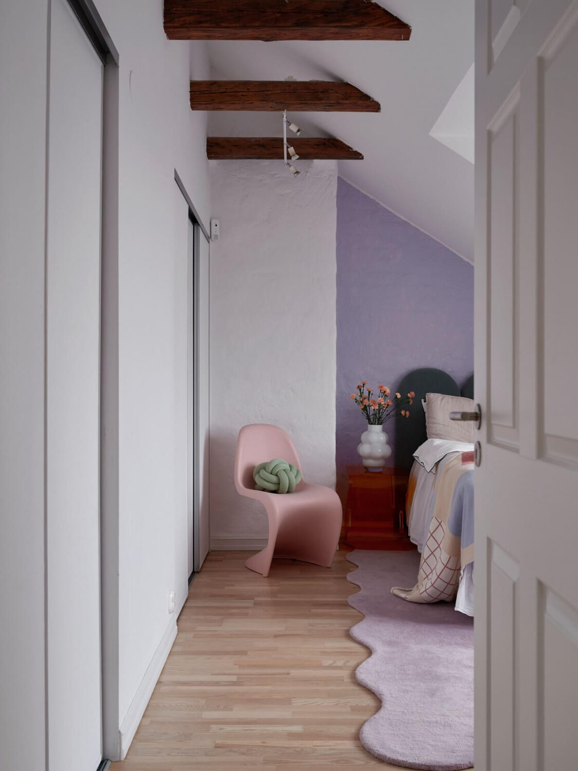 Pastel Color Accents in a Scandinavian Penthouse Apartment 14 bedroom-slanted-ceiling-exposed-beams-lavender-wall-nordroom