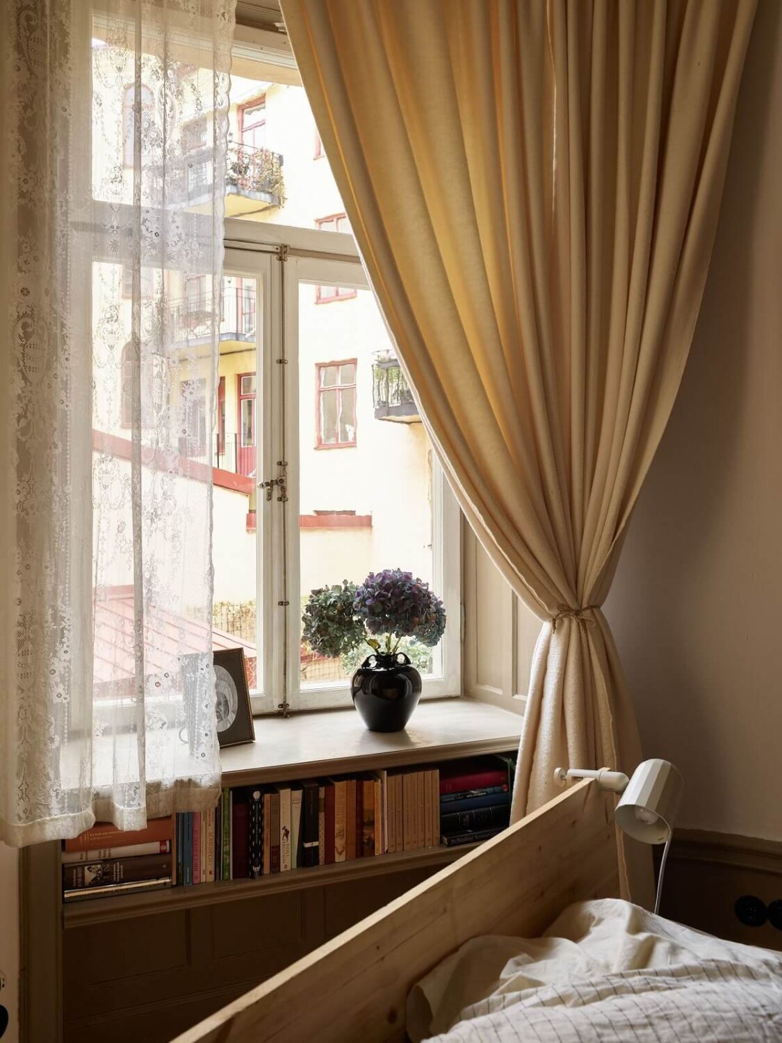 A Beige Vintage Apartment in Stockholm 20 beige-bedroom-storage-bookshelf-in-window-nordroom