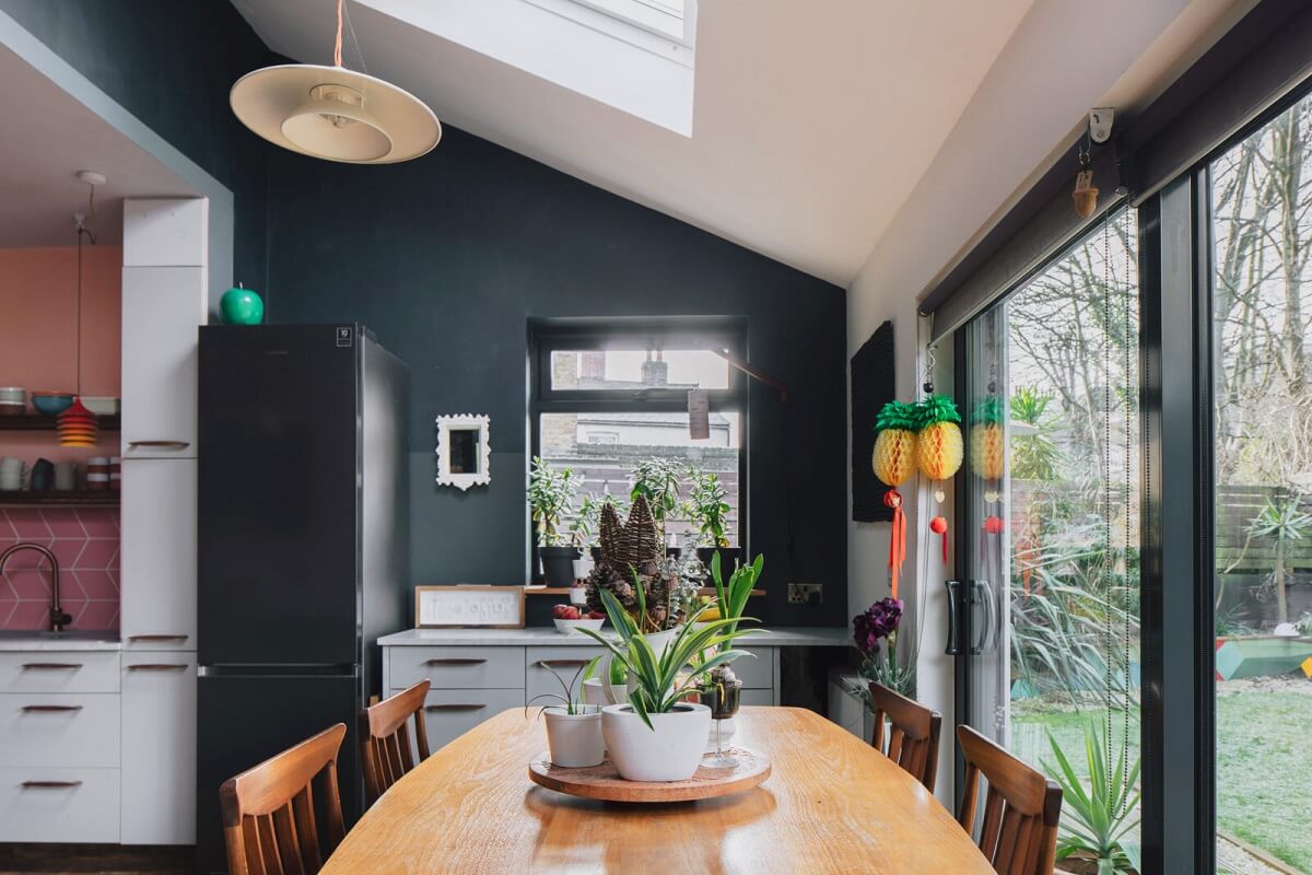 A London Home with Moody Rooms and a Pink Kitchen 6 dining-room-dark-green-walls-slanted-ceiling-skylights-nordroom