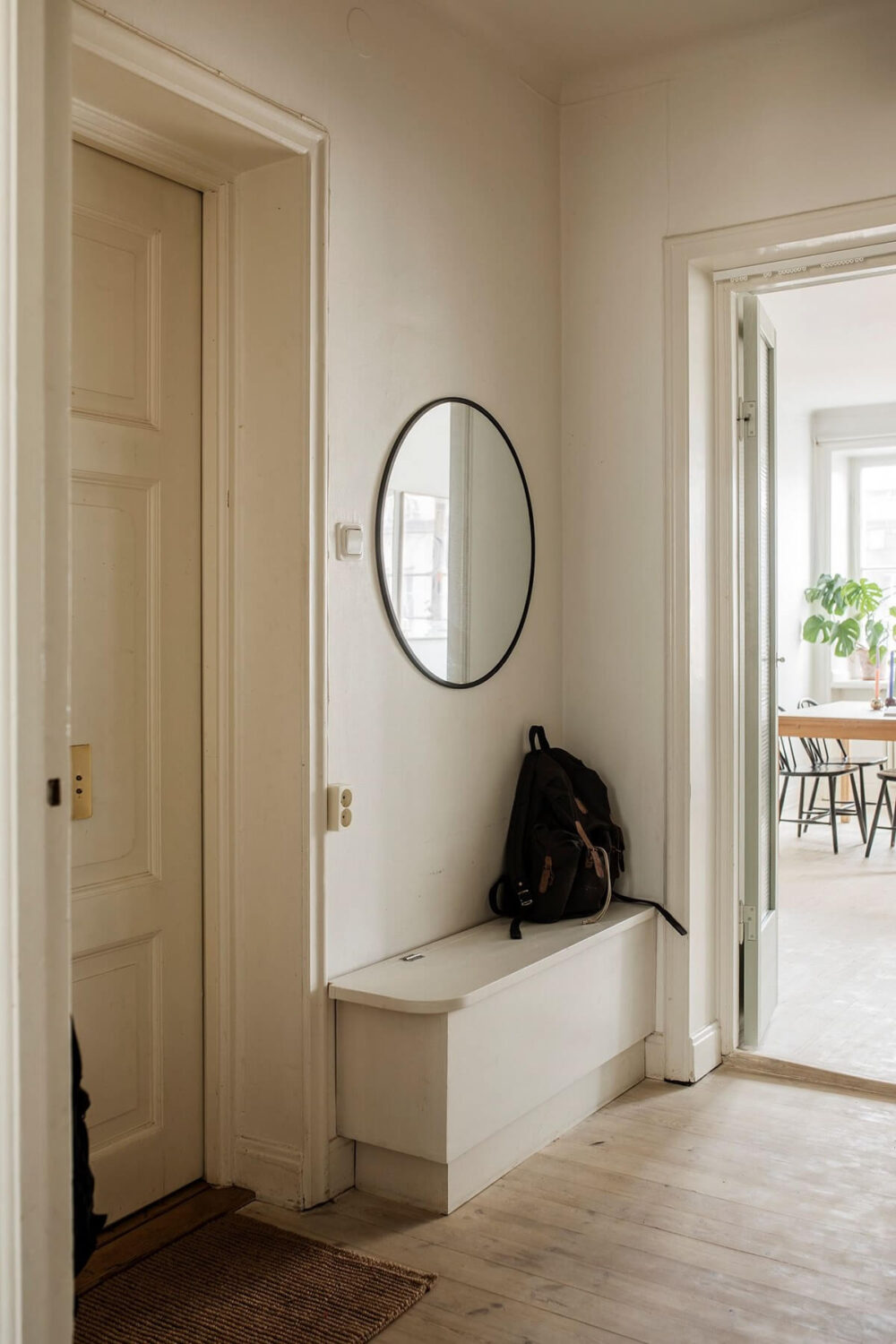 A Small Swedish Apartment Decorated in Midcentury Style 15 hallway-built-in-bench-round-mirror-nordroom