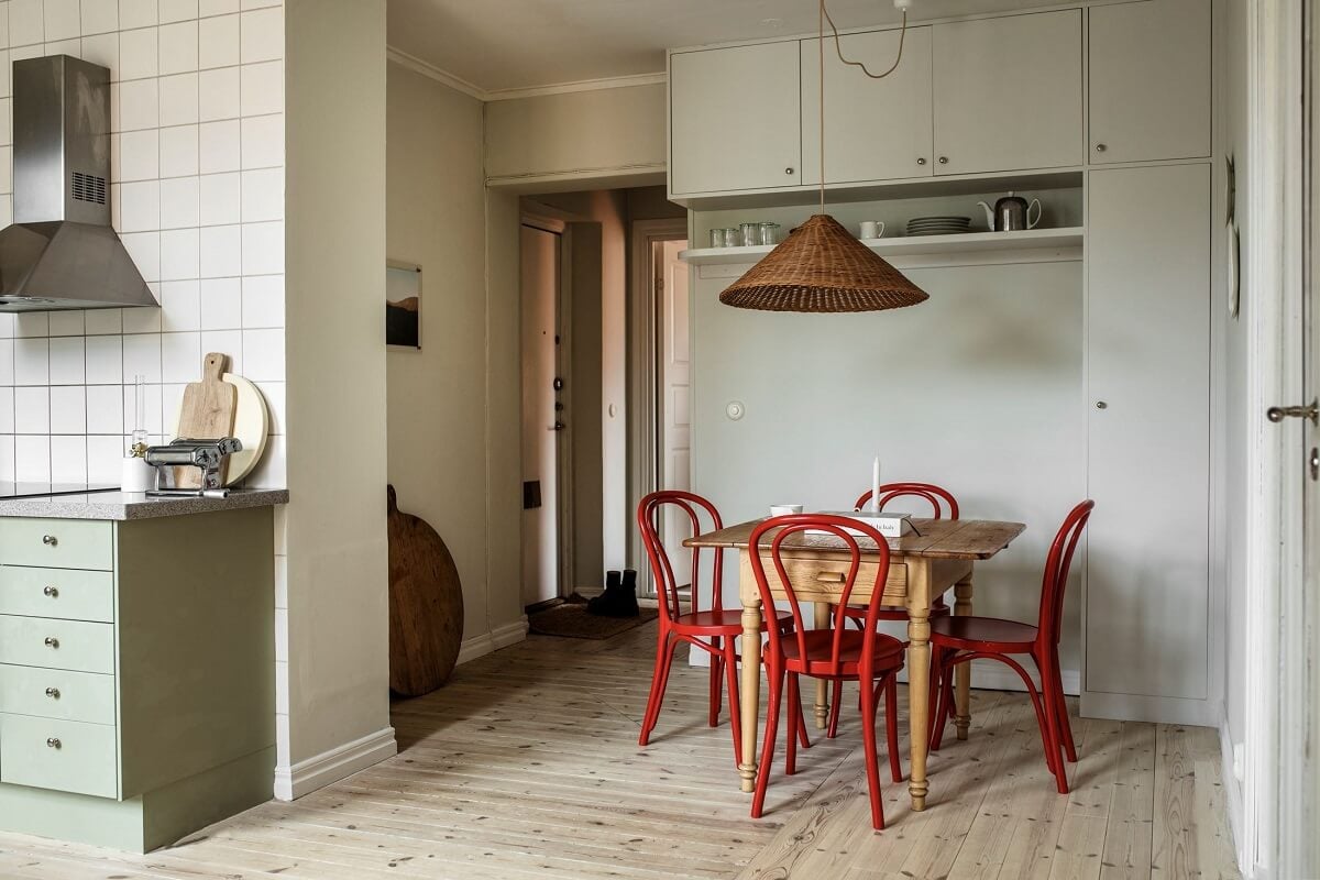 A Serene Light Colored Apartment in Stockholm 8 kitchen-dining-area-red-chairs-wooden-floor-nordroom