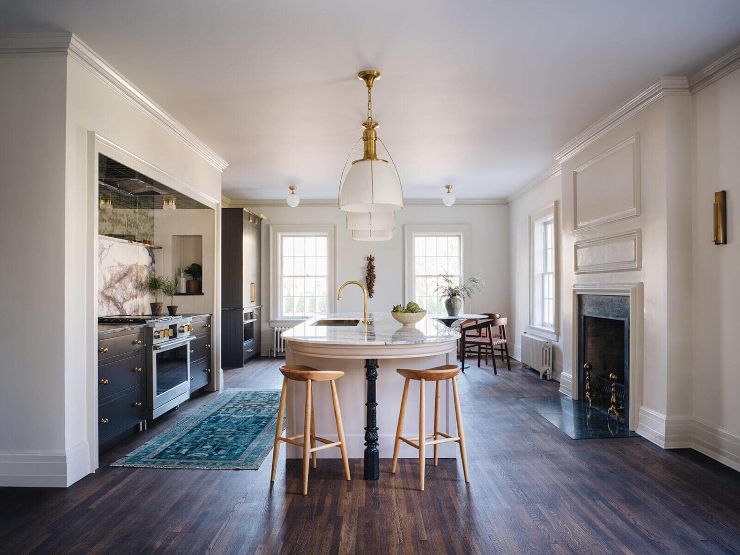 A Classic 1930s Home in Grand Rapids Designed by Jean Stoffer 7 large-kitchen-fireplace-wooden-floor-round-kitchen-island-breakfast-bar-nordroom