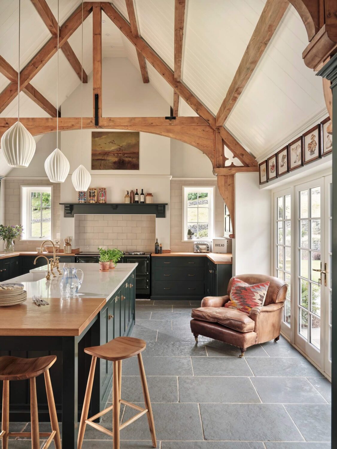 A Grand Family Kitchen in an English Country House 5 large-kitchen-island-flagstone-floor-leather-armchair-exposed-wooden-beams-devol-nordroom