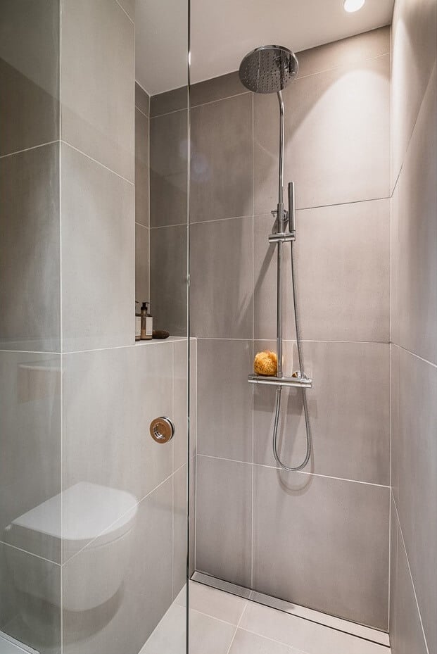 An Oslo Apartment with Custom Made Storage Solutions 17 minimalistic gray bathroom walk in shower nordroom An Oslo Apartment with Custom Made Storage Solutions