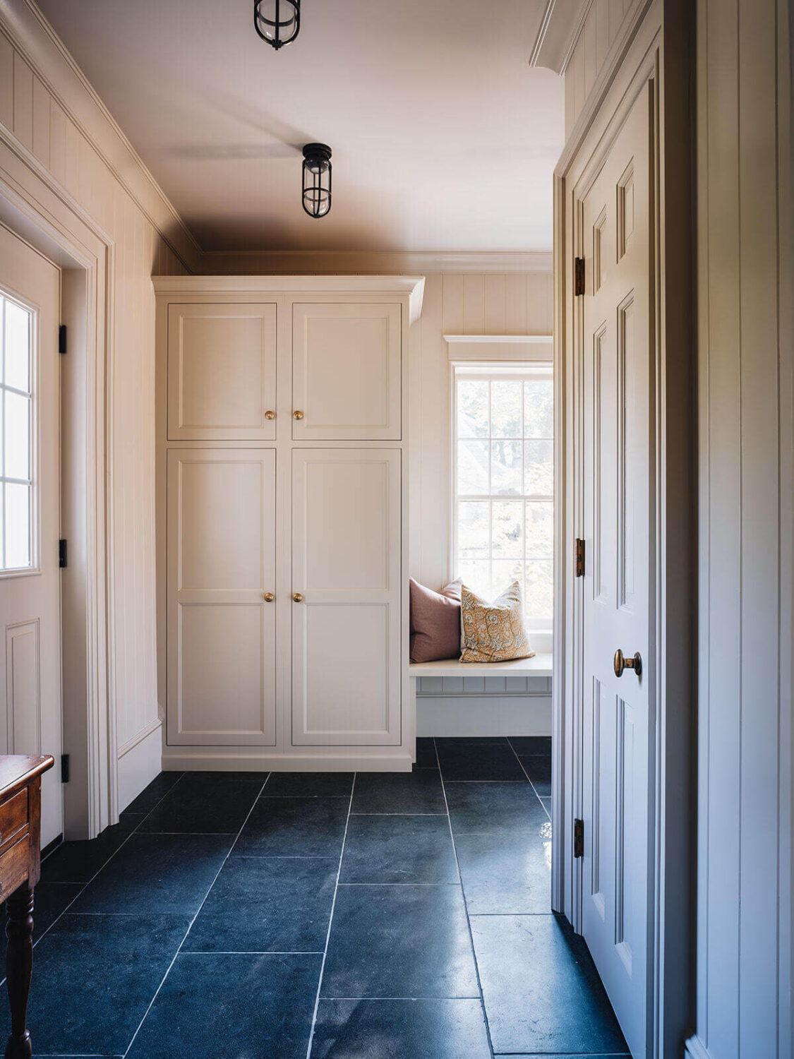A Classic 1930s Home in Grand Rapids Designed by Jean Stoffer 20 mudroom-window-seat-built-in-wardrobes-dark-gray-floor-tiles-nordroom