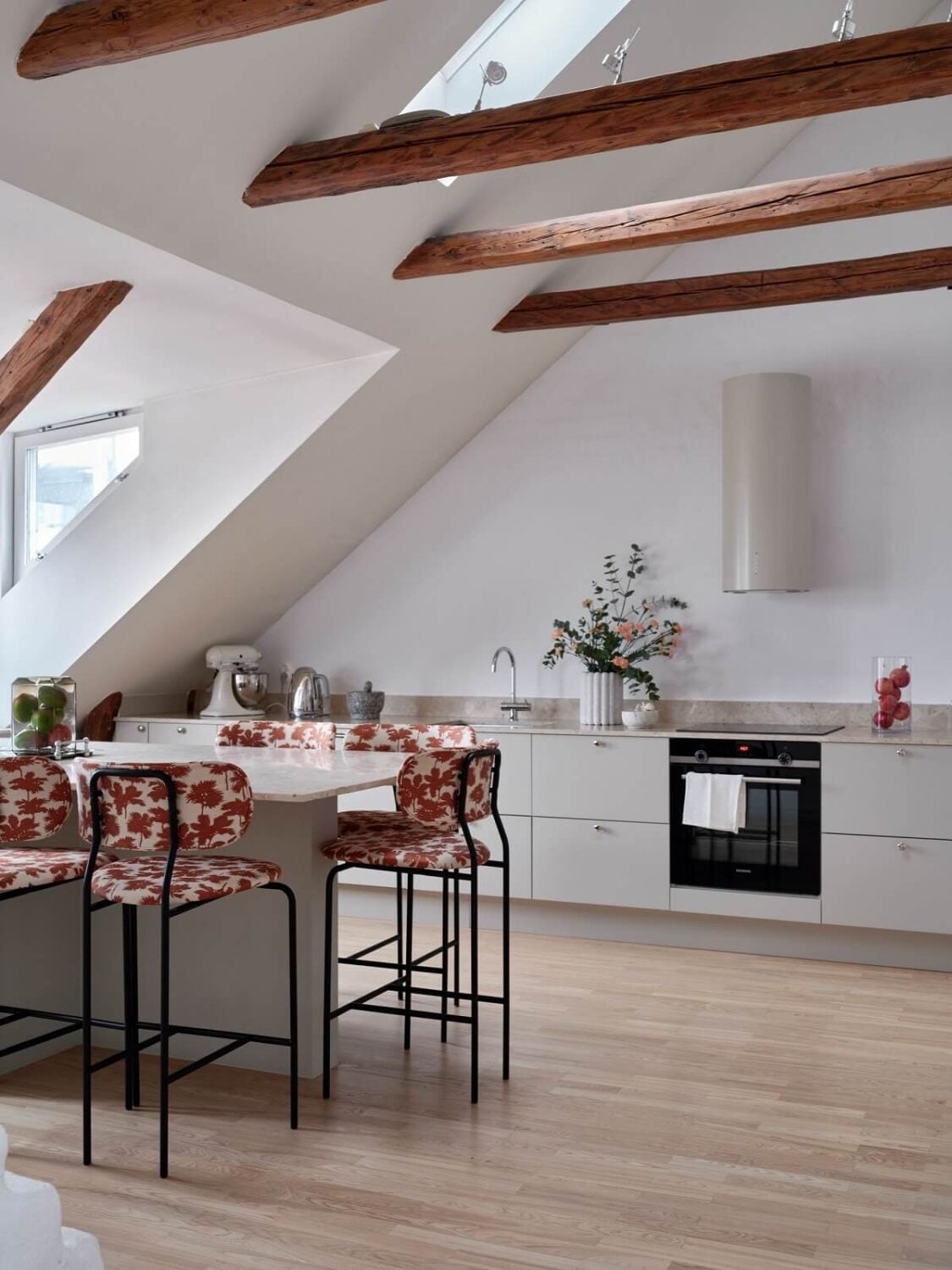 Pastel Color Accents in a Scandinavian Penthouse Apartment 8 penthouse-apartment-slanted-ceiling-exposed-wooden-beams-kitchen-colorful-bar-stools-nordroom