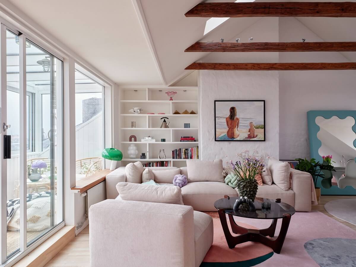 Pastel Color Accents in a Scandinavian Penthouse Apartment 2 sitting-room-bookshelfs-pastel-color-accents-wooden-ceiling-beams-nordroom