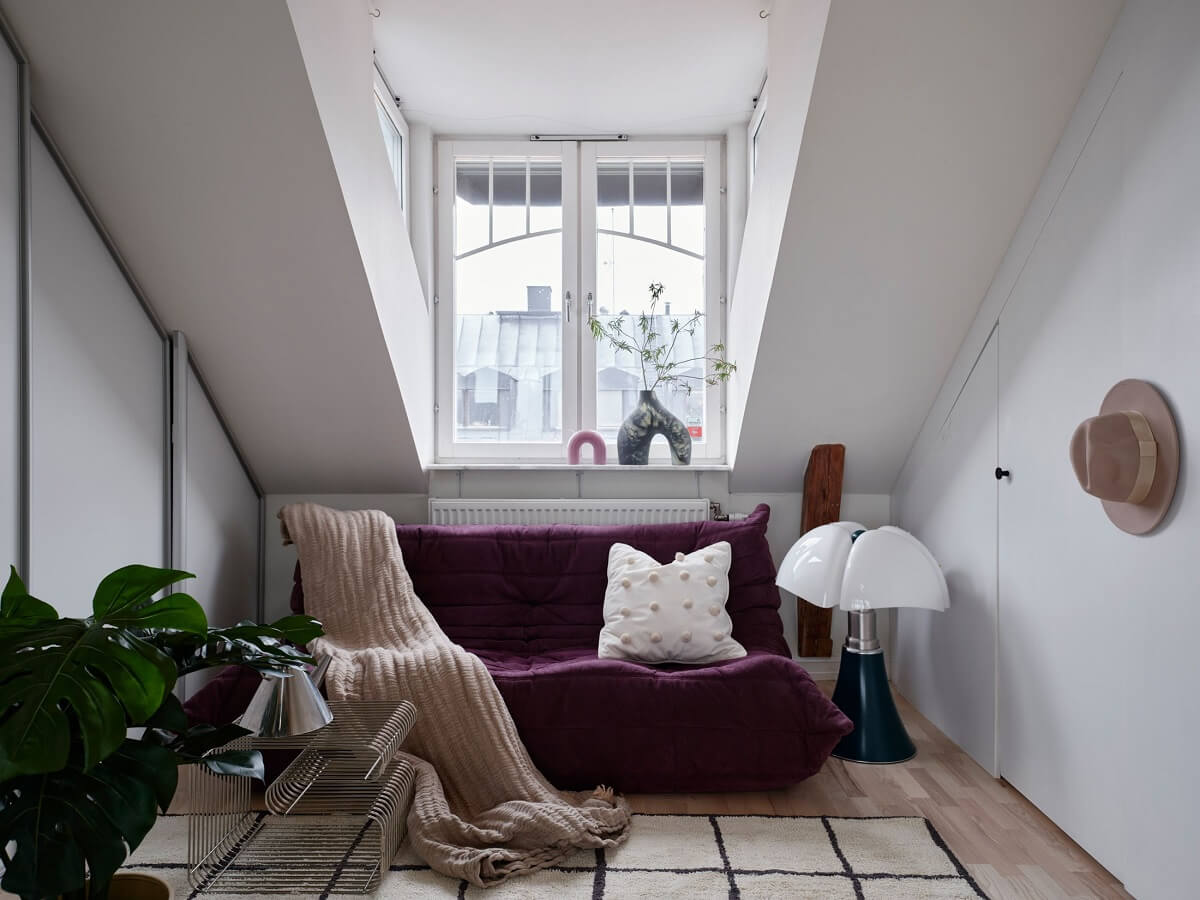 Pastel Color Accents in a Scandinavian Penthouse Apartment 11 sitting-room-purple-togo-sofa-slanted-ceiling-nordroom