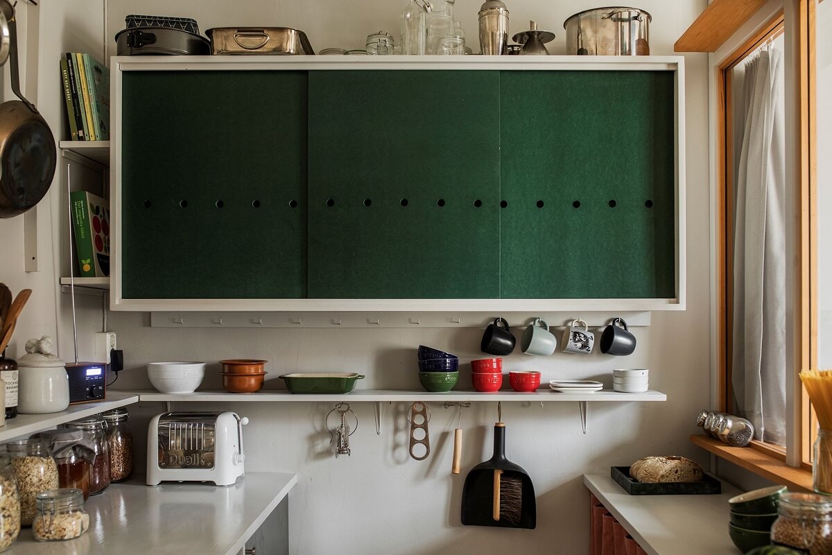 A Small Swedish Apartment Decorated in Midcentury Style 6 small-kitchen-green-cabinets-sliding-doors-nordroom