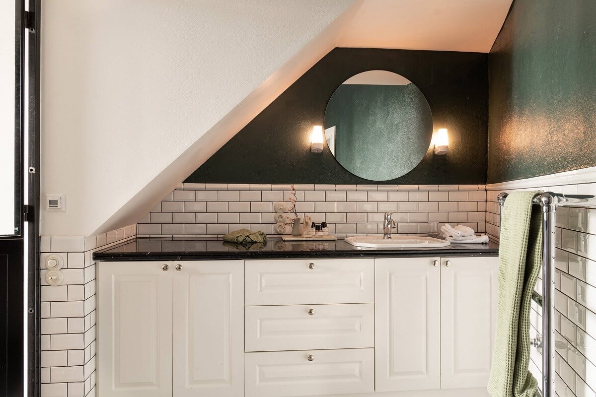 A Classic Maisonette Home in Stockholm 14 bathroom-slanted-ceiling-round-mirror-white-subway-tiles-nordroom