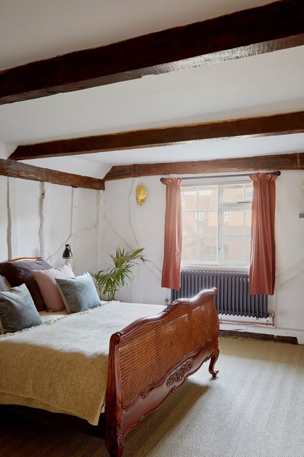 A Pink English Home That's Brimming with History 19 bedroom-exposed-beams-antique-bedframe-nordroom