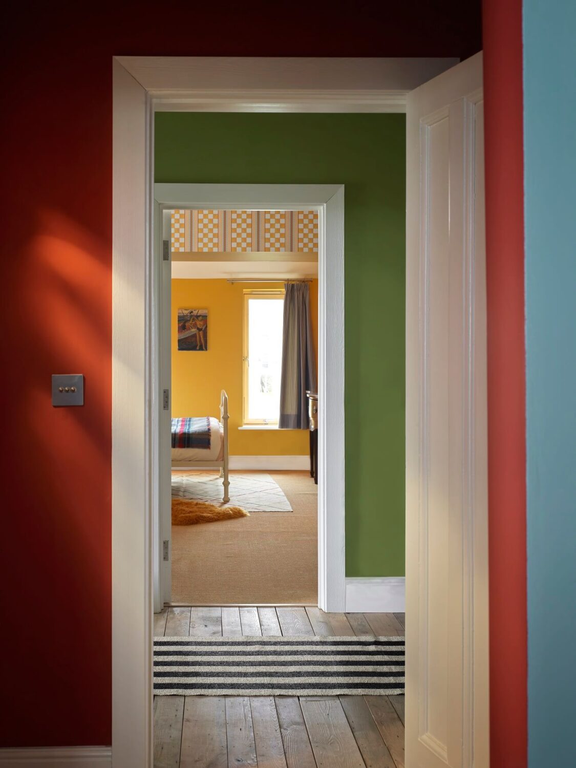 A Colorful House By The Sea Designed by Space A 12 colorful-home-red-green-yellow-walls-striped-rug-nordroom
