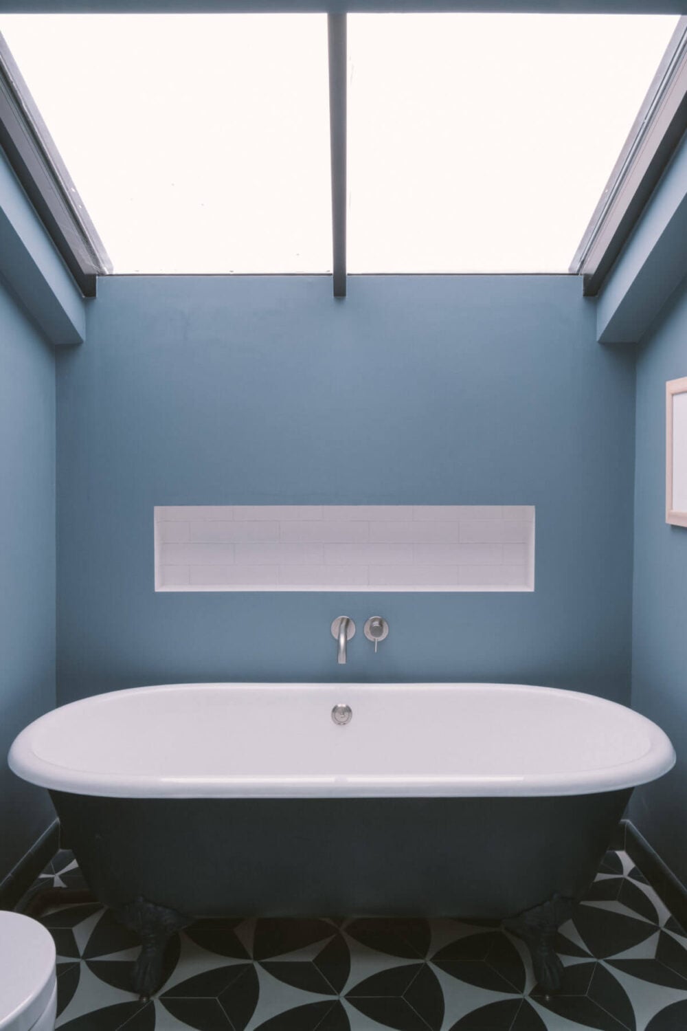 A Modern Split-Level Home with Colorful Rooms 25 freestanding-bath-blue-walls-skylight-nordroom