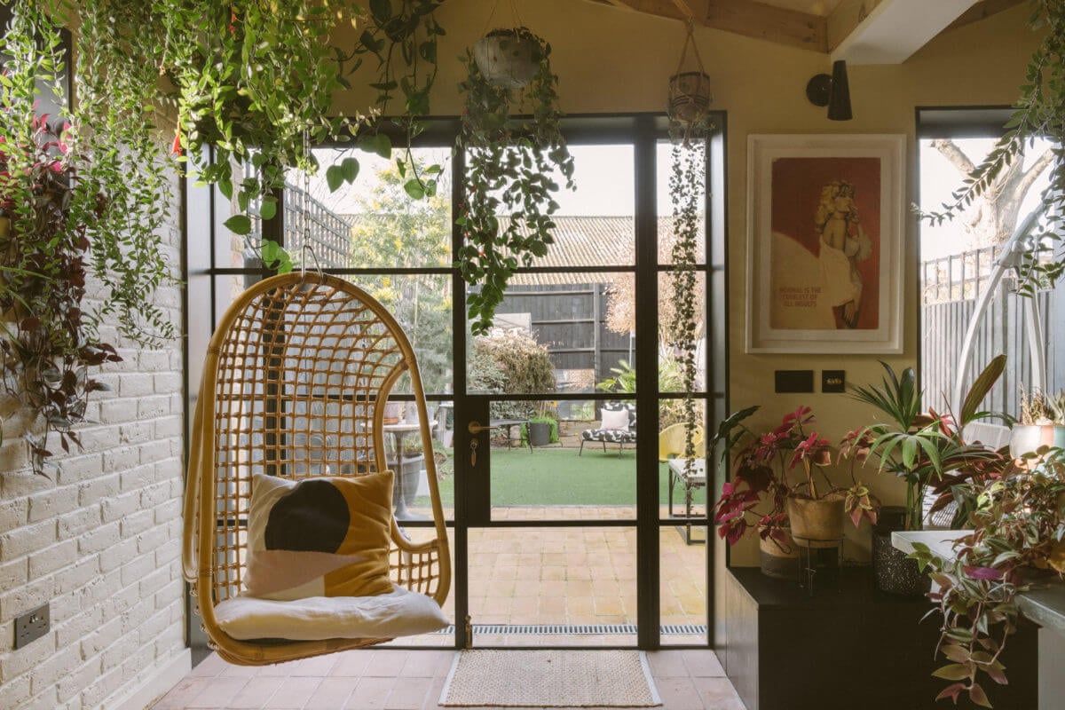 A Victorian House in London Decorated in Warm Color Tones 6 hanging-rattan-chair-plants-crittal-doors-nordroom