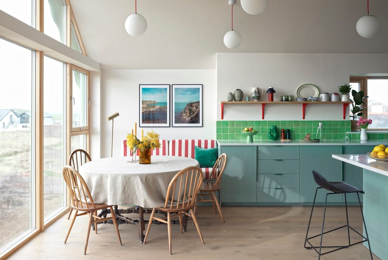 A Colorful House By The Sea Designed by Space A 2 kitchen-blue-cabinets-dining-space-bench-striped-red-fabrics-green-backsplash-tiles-nordroom