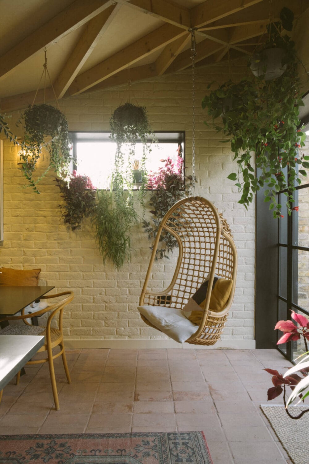 A Victorian House in London Decorated in Warm Color Tones 5 kitchen-stone-floor-wooden-beams-hanging-rattan-chair-plants-nordroom