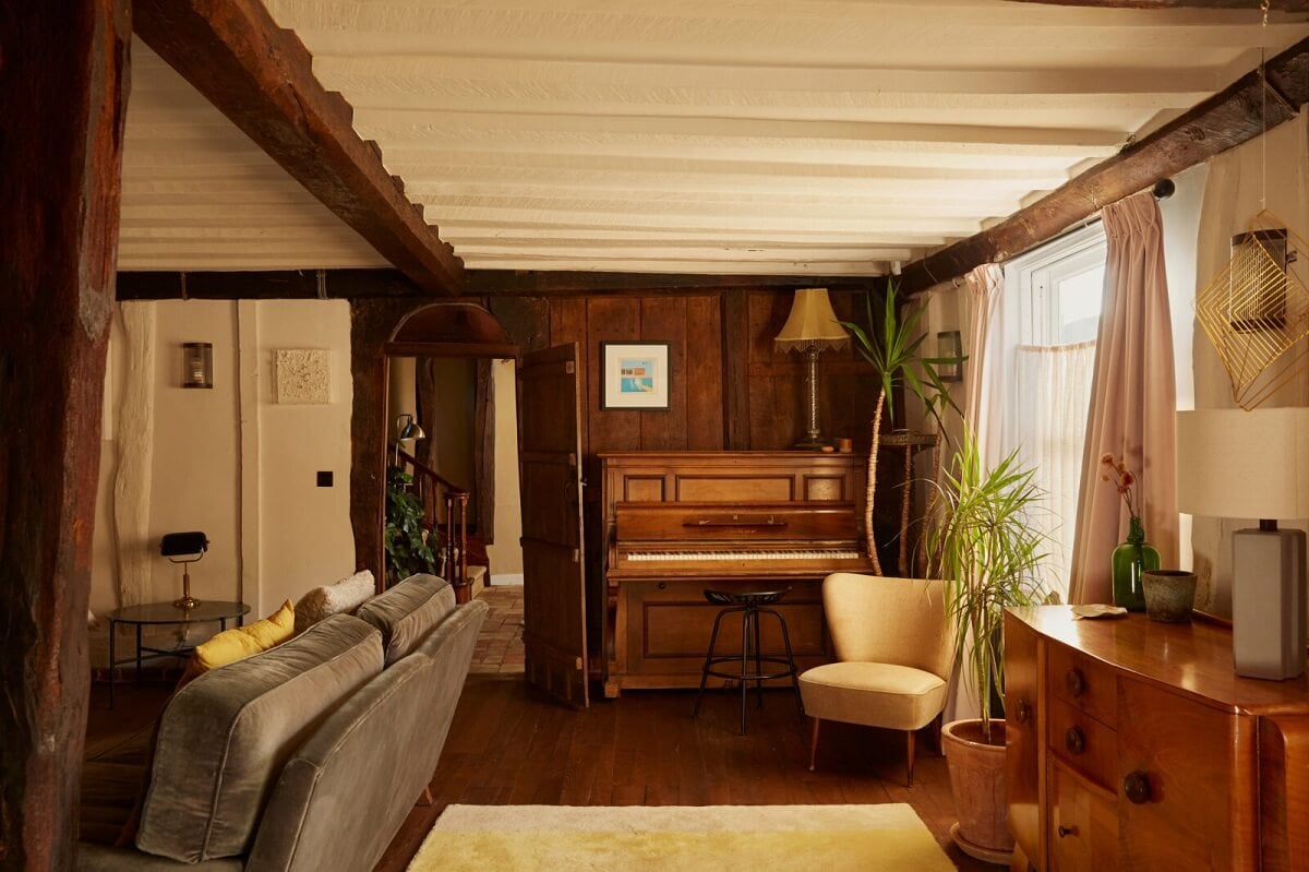 A Pink English Home That's Brimming with History 4 living-room-piano-wooden-wall-exposed-wooden-beams-nordroom