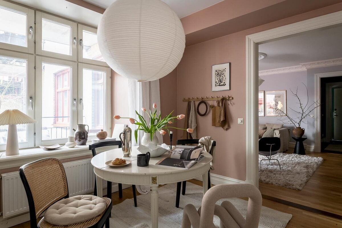 Layered Textiles and Dusty Colors in a Nordic Apartment 12 round-dining-table-mixture-of-chairs-dusty-pink-walls-nordroom