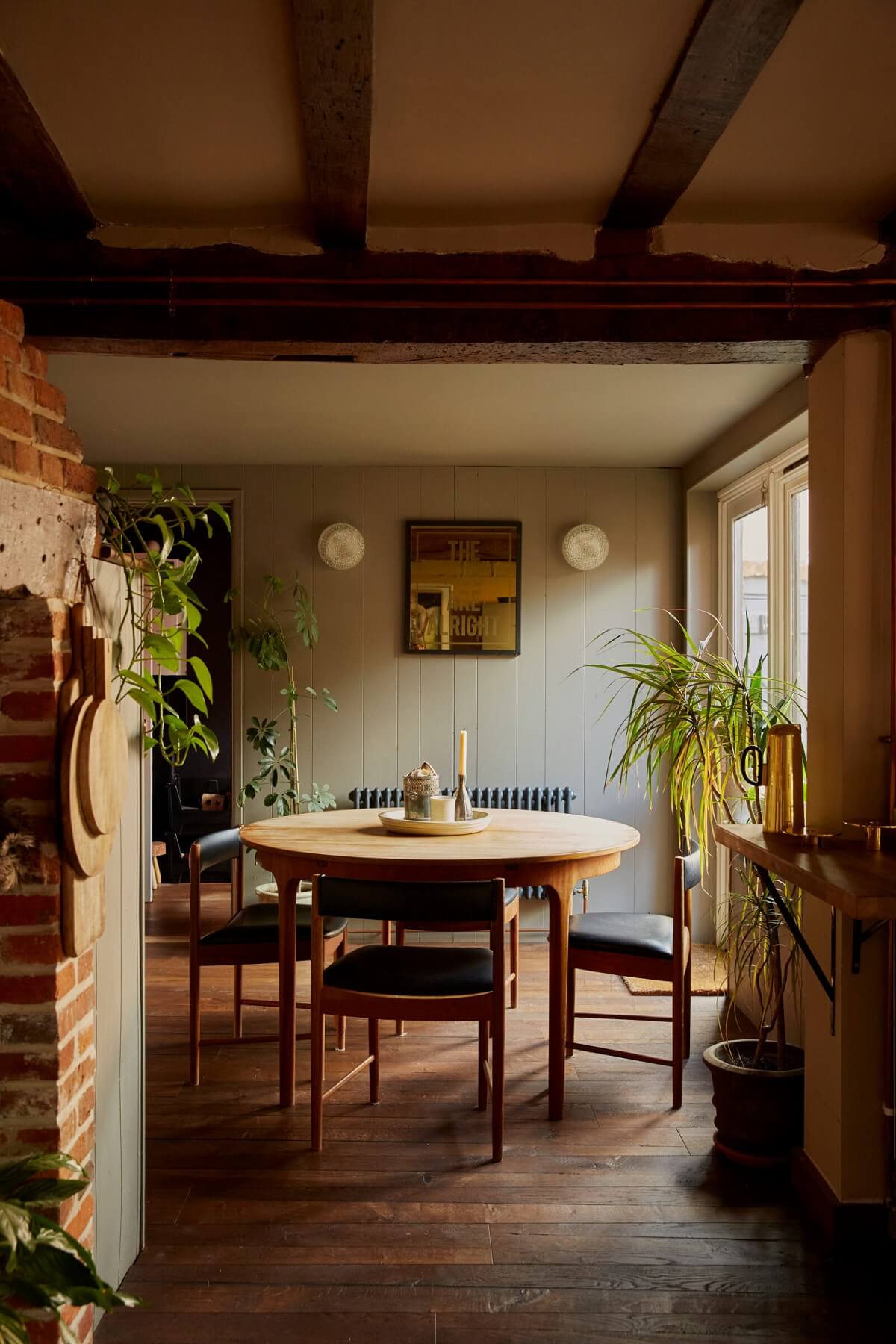 round-dining-table-wooden-floor-exposed-beams-nordroom