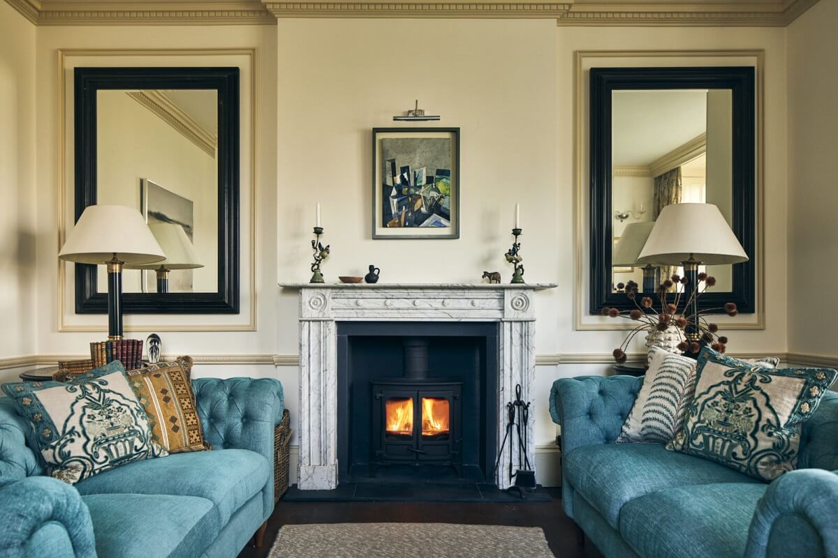 A Peaceful Georgian House in the English Countryside 3 sitting-room-blue-sofas-fireplace-mirrors-nordroom