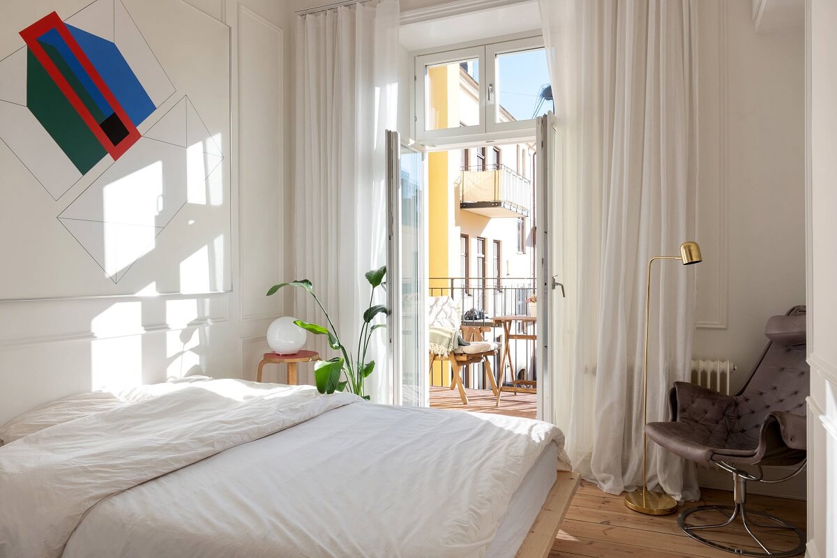 A Small Stockholm Apartment with Lovely Natural Light 11 all white bedroom wooden floor balcony