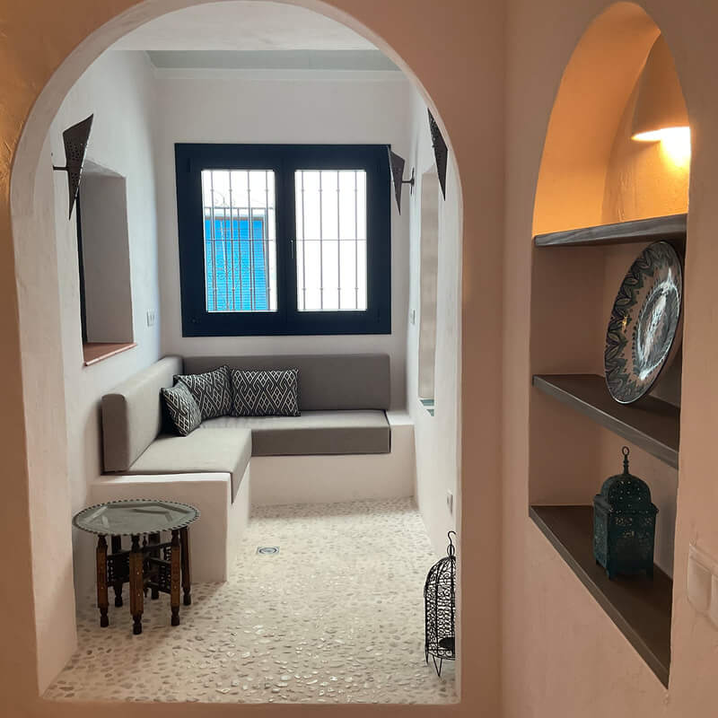 Casita Alborán: A Stylish Home in a Spanish Seaside Town 12 arched-doorway-indoor-patio-moroccan-inspired-pebble-floor-nordroom